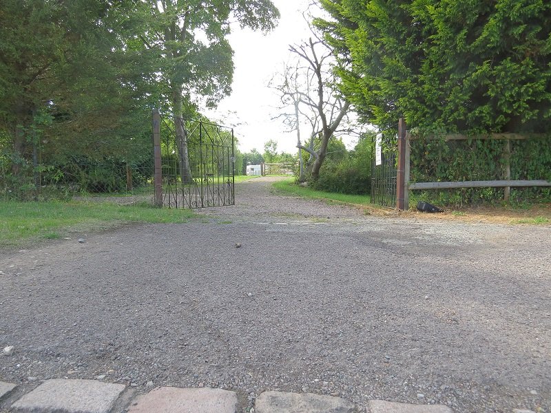 The gated entrance to the site, seen from the road.